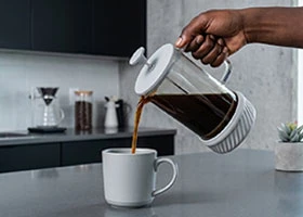 Coffee brewing setup in a Kenyan home kitchen with French press and accessories